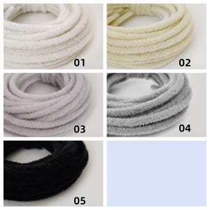 May include: Five coiled plush headbands in a range of colours: white, cream, light grey, dark grey, and black. Each headband is shown against a white background, with a number label on each.