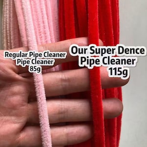 May include: A comparison of two pipe cleaners: a light pink version labeled Regular Pipe Cleaner 85g and a vibrant red version labeled Our Super Dence Pipe Cleaner 115g. The image highlights the difference in texture and density between the two items.