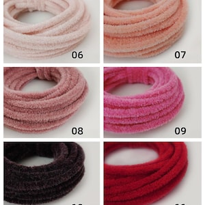 May include: Six colourful scrunchies in a grid arrangement. The scrunchies are in shades of light pink, peach, mauve, hot pink, dark purple, and red. Each scrunchie is labelled with a number from 06 to 11.
