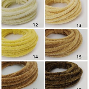 May include: Six scrunchies in a range of colours from pale yellow to dark brown. Each is made from a soft, textured fabric and numbered 12 to 17. The scrunchies are displayed in a grid, highlighting their different shades and textures.