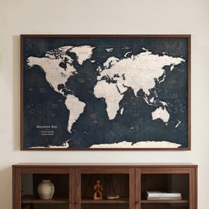 Puede incluir: Un mapa de pared rectangular con un fondo azul marino oscuro y continentes de color crema claro. El texto "UNCHARTED ASIA", "Trails of the Past" y "Journeys Ahead" está impreso en blanco en la parte inferior izquierda del mapa.