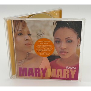 May include: A clear plastic CD case with the album "thankful" by Mary Mary. The cover features two women and the text "MARY MARY" in pink and purple. The CD case is open, revealing the disc.