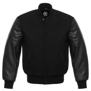 Könnte beinhalten: Eine schwarze Collegejacke mit einem Körper aus Wollmischgewebe und langen Lederärmeln. Die Jacke verfügt über einen gerippten Kragen, Bündchen und Saum, eine Druckknopfleiste, zwei Seitentaschen und ein kreisförmiges Logo am Innenetikett.