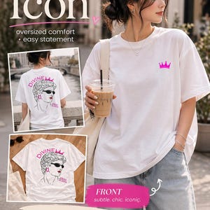 Könnte beinhalten: Weißes T-Shirt mit einer pinkfarbenen Kronengrafik auf der Vorderseite. Auf der Rückseite des Shirts befindet sich eine Grafik einer Frau mit Sonnenbrille und dem Text "DIVINE QUEEN". Das Shirt hat eine lockere, übergroße Passform.