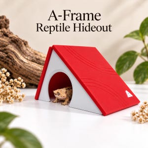 May include: An A-frame reptile hideout with a bright red roof and white sides. The structure features an arched entrance and a small white letter A logo on the side. A small crested gecko is visible inside the shelter. Text reads A-Frame Reptile Hideout.