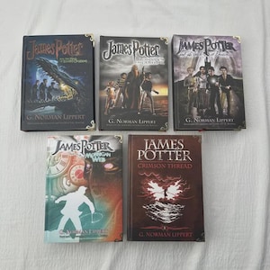 May include: Five hardcover books titled "James Potter" by G. Norman Lippert. The covers feature illustrations of characters and scenes, with titles like "The Hall of Eldridge Crossing" and "Crimson Thread".