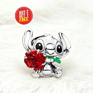 May include: A silver Stitch figurine holding a red rose with a green stem. The figurine has large black eyes and ears. A red circle with the text "BUY 2 GET 1 FREE" is in the upper left corner. The background is white.