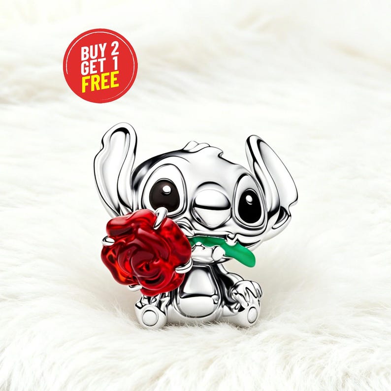 May include: A silver Stitch figurine holding a red rose with a green stem. The figurine has large black eyes and ears. A red circle with the text "BUY 2 GET 1 FREE" is in the upper left corner. The background is white.