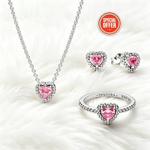 May include: A jewelry set featuring a necklace, earrings, and ring. Each piece has a heart-shaped pink stone surrounded by clear stones. The ring and earrings are silver-toned, and the necklace has a silver chain. The image includes a "SPECIAL OFFER" sticker.