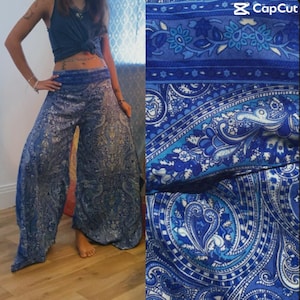 Pode incluir: Calças palazzo com estampa paisley azul. As calças de perna larga apresentam um padrão detalhado em tons de azul e branco. O tecido parece leve e fluido. As calças são mostradas com um top azul.