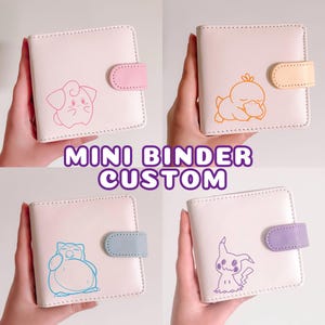 May include: Four square mini binders in off-white with a snap closure. Each binder features a different colored character outline: pink Clefairy, orange Psyduck, blue Snorlax, and purple Mimikyu. The text MINI BINDER CUSTOM is centered in the middle.