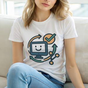 Könnte beinhalten: Weißes T-Shirt mit einem farbenfrohen Grafikdesign eines Computers mit Smiley-Gesicht, Pfeilen und einem Häkchen. Das Design ist in Blau-, Grün- und Orangetönen gehalten. Das T-Shirt wird getragen.