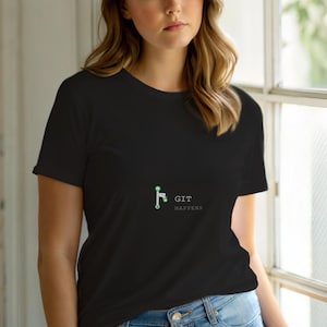 May include: Black t-shirt with the text "GIT HAPPENS" in white. The shirt features a small graphic of a green and white design. The t-shirt is made of a soft material and is suitable for casual wear.