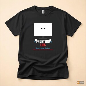 Op de afbeelding: Zwart t-shirt met een witte computermonitor afbeelding en de tekst "FRONTEND LIES, BACKEND CRIES" in blauw en rood. Het ontwerp toont een monitor met twee zwarte stippen.