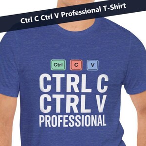 Könnte beinhalten: Ein blaues T-Shirt mit dem weißen Text "CTRL C CTRL V PROFESSIONAL". Über dem Text befinden sich drei farbige Tastaturtasten: grün, rot und blau. Das Shirt hat auch den Text "Ctrl C Ctrl V Professional T-Shirt" auf einem schwarzen Banner.