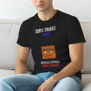 May include: Black t-shirt with the text "ZERO TRUST CLUB" above an orange padlock graphic with an angry face. Below the graphic is the text "ACCESS DENIED UNTIL PROVEN".