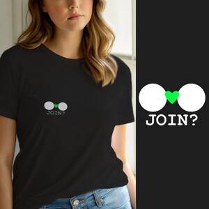 Peut inclure: Un t-shirt noir à manches courtes avec un petit motif sur la poitrine gauche. Le motif se compose de deux cercles blancs séparés par un petit cœur vert, avec le texte blanc "JOIN?" imprimé directement sous les cercles.
