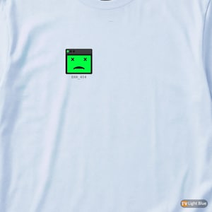May include: Light blue long-sleeve shirt with a small graphic on the upper left chest. The graphic is a green computer window with a sad face and two X's, with the text "ERR_404" below it. The shirt is made of a soft material.