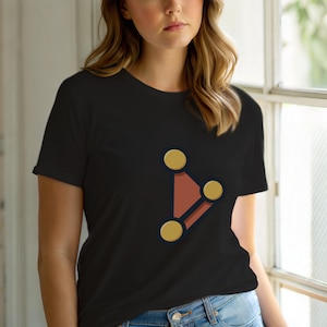 Op de afbeelding: Zwart T-shirt met een geometrisch ontwerp. De afbeelding bestaat uit drie gouden cirkels die zijn verbonden door een roodbruine vorm met donkerblauwe contouren. Het ontwerp is gecentreerd op de voorkant van het shirt.