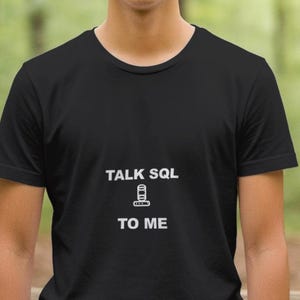 Könnte beinhalten: Schwarzes T-Shirt mit Rundhalsausschnitt und dem weißen Text "TALK SQL TO ME". Das Design beinhaltet eine Grafik eines Datenbank-Symbols. Das Shirt besteht aus einem weichen Material und eignet sich für Freizeitkleidung.