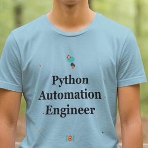 May include: A light blue t-shirt with the words "Python Automation Engineer" printed in black. The shirt has a crew neck and short sleeves. The shirt also has a small graphic above the text.