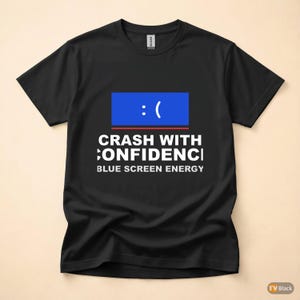 May include: Black t-shirt with a blue square graphic featuring a sad face and the text "CRASH WITH CONFIDENCE" and "BLUE SCREEN ENERGY" in white. The shirt is made of a soft material.