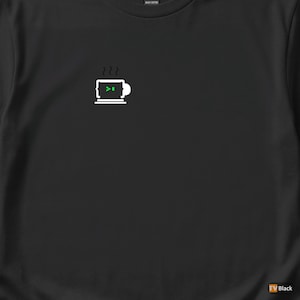 May include: Black t-shirt featuring a white graphic of a coffee cup with a laptop screen design. The laptop screen displays a green code symbol. The shirt is made of heavy cotton.