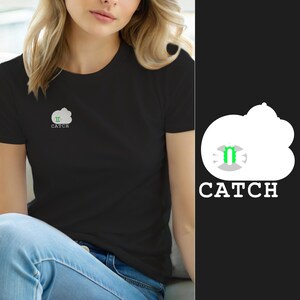 Könnte beinhalten: Ein schwarzes T-Shirt mit kurzen Ärmeln und einer weißen, wolkenförmigen Grafik auf der linken Brust. In der Wolke befindet sich ein kleines graues und hellgrünes Symbol. Das Wort CATCH ist in weißen Großbuchstaben unter der Grafik gedruckt.