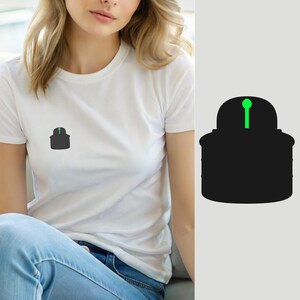 Peut inclure: Un t-shirt blanc à manches courtes avec un petit motif centré sur la poitrine. Le motif est une silhouette noire unie représentant un récipient arrondi avec une ligne verticale vert néon vif et un petit cercle détaillé en haut au centre.