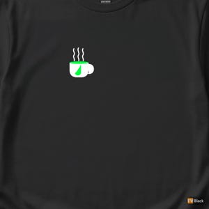May include: Black t-shirt with a white coffee cup graphic, green filling, and steam. The design is minimalist, suitable for casual wear. The shirt is made of heavy cotton.