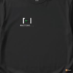 Può includere: T-shirt nera con grafica bianca di una barra di caricamento e la scritta "WAITING...". La barra di caricamento ha un indicatore di avanzamento verde. La maglietta è in cotone pesante.