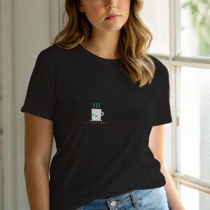 May include: Black t-shirt featuring a green and white coffee cup design with steam and the text "</COFFEE>". The shirt is made of a soft material.