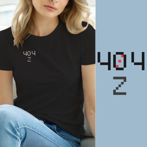 May include: A black short-sleeved t-shirt featuring a small pixelated graphic on the left chest. The graphic displays the text 404 with a red pixelated square inside the zero, and the letter Z positioned directly below the number 404 in white.