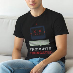 Puede incluir: Camiseta negra con un diseño de robot y detalles rojos. El texto "ERROR 429... THOUGHTS TRUNCATED" está presente. El robot tiene ojos en forma de X y tres puntos. La camiseta la lleva una persona.