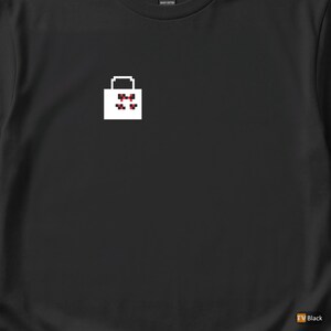 May include: Black t-shirt featuring a white pixelated shopping bag design with red accents. The graphic is centered on the chest. The shirt is made of a soft, comfortable material.