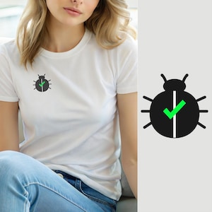 Op de afbeelding: Een wit T-shirt met korte mouwen en een kleine, gecentreerde afbeelding op de borst. De afbeelding is een zwart, rond kever-icoon met een verticale witte lijn in het midden en een felgroen vinkje dat aan de linkerkant is geplaatst.