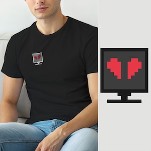 Könnte beinhalten: Ein schwarzes T-Shirt mit kurzen Ärmeln und einer kleinen Grafik auf der Brust, die einen grauen Computermonitor mit einem roten, verpixelten Herzsymbol zeigt. Das Design ist schlicht gehalten und das Symbol befindet sich auf der linken Seite.