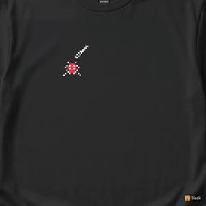 May include: Black t-shirt featuring a pixelated red and white graphic. The graphic appears to be a stylized representation of a ladybug or similar insect. The shirt is made of a heavy cotton material.
