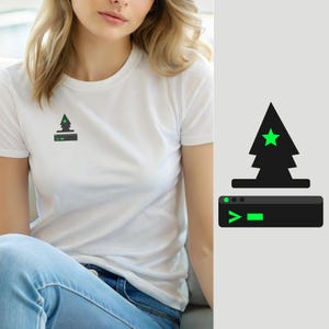 Peut inclure: Un t-shirt blanc à manches courtes avec un motif sur la poitrine. Le graphisme représente un sapin noir stylisé avec une étoile vert vif au centre, placé au-dessus d'une icône de fenêtre de terminal informatique noire avec un symbole de commande vert.