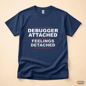 Pode incluir: Camiseta azul marinho com o texto branco "DEBUGGER ATTACHED FEELINGS DETACHED", com linhas vermelhas acima e abaixo. A camiseta é de gola redonda.