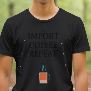 Può includere: T-shirt nero con la scritta "IMPORT COFFEE REPEAT" in un carattere stilizzato. Sotto, una grafica di una tazza di caffè fumante. Girocollo.
