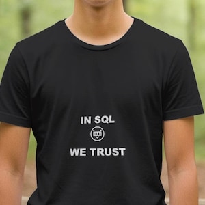 Könnte beinhalten: Schwarzes T-Shirt mit Rundhalsausschnitt und dem weißen Text "IN SQL WE TRUST" sowie einer Grafik eines stilisierten Datenbanksymbols. Das Shirt besteht aus einem weichen Material und eignet sich für Freizeitkleidung.