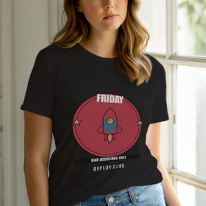 May include: Black t-shirt with a circular graphic. The graphic features a rocket ship design, the word "FRIDAY", and the text "BAD DECISIONS ONLY DEPLOY CLUB". Two stars are on either side of the rocket ship.