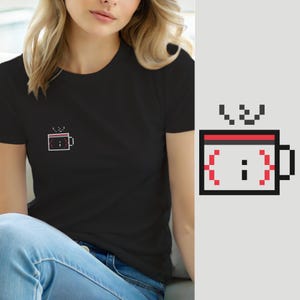 May include: A black short-sleeved t-shirt featuring a small pixel art graphic on the left chest. The graphic depicts a white coffee mug with a black outline, a red top rim, and a red semicolon symbol enclosed within red curly brackets.