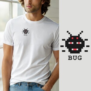 Op de afbeelding: Een wit T-shirt met korte mouwen en een kleine, zwarte, gepixelde insectafbeelding op de linkerborst. Het ontwerp bevat rode gepixelde details voor de ogen en mond, met het woord "BUG" in zwarte letters direct onder het icoon gedrukt.