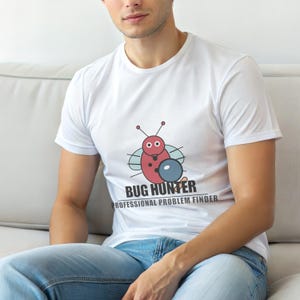 May include: White t-shirt featuring a cartoon bug with a shield and the text "BUG HUNTER PROFESSIONAL PROBLEM FINDER". The shirt is made of a soft material and is suitable for casual wear.