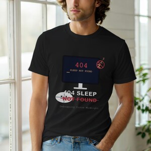 May include: Black t-shirt featuring a computer screen graphic displaying "404 Sleep Not Found." Below the screen is the text "404 Sleep Not Found" with a line through "Not Found." The phrase "Debugging Since Midnight" is also printed on the shirt.