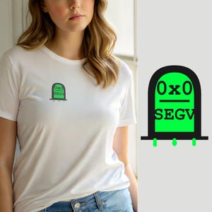 May include: A white short-sleeved t-shirt featuring a small graphic on the left chest. The graphic is a black arched outline filled with bright green, containing the black text 0x0 above a horizontal line and the black text SEGV below it.