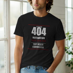 Pode incluir: T-shirt preto com o texto "ERROR 404 MOTIVATION NOT FOUND TRY AGAIN TOMORROW" em branco e vermelho. A camisa tem gola redonda e mangas curtas.