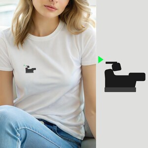 Może przedstawiać: Biały t-shirt z krótkim rękawem z małą, wyśrodkowaną grafiką na klatce piersiowej. Grafika przedstawia sylwetkę ciemnoszarego krzesła z czarnym zagłówkiem oraz mały, jaskrawozielony trójkąt skierowany w lewy górny róg.